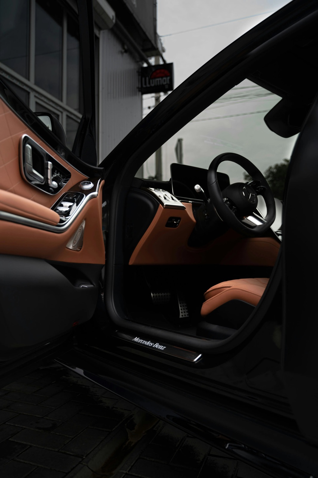 Open door of a Mercedes-Benz coupe showing a detailed black and saddle leather interior